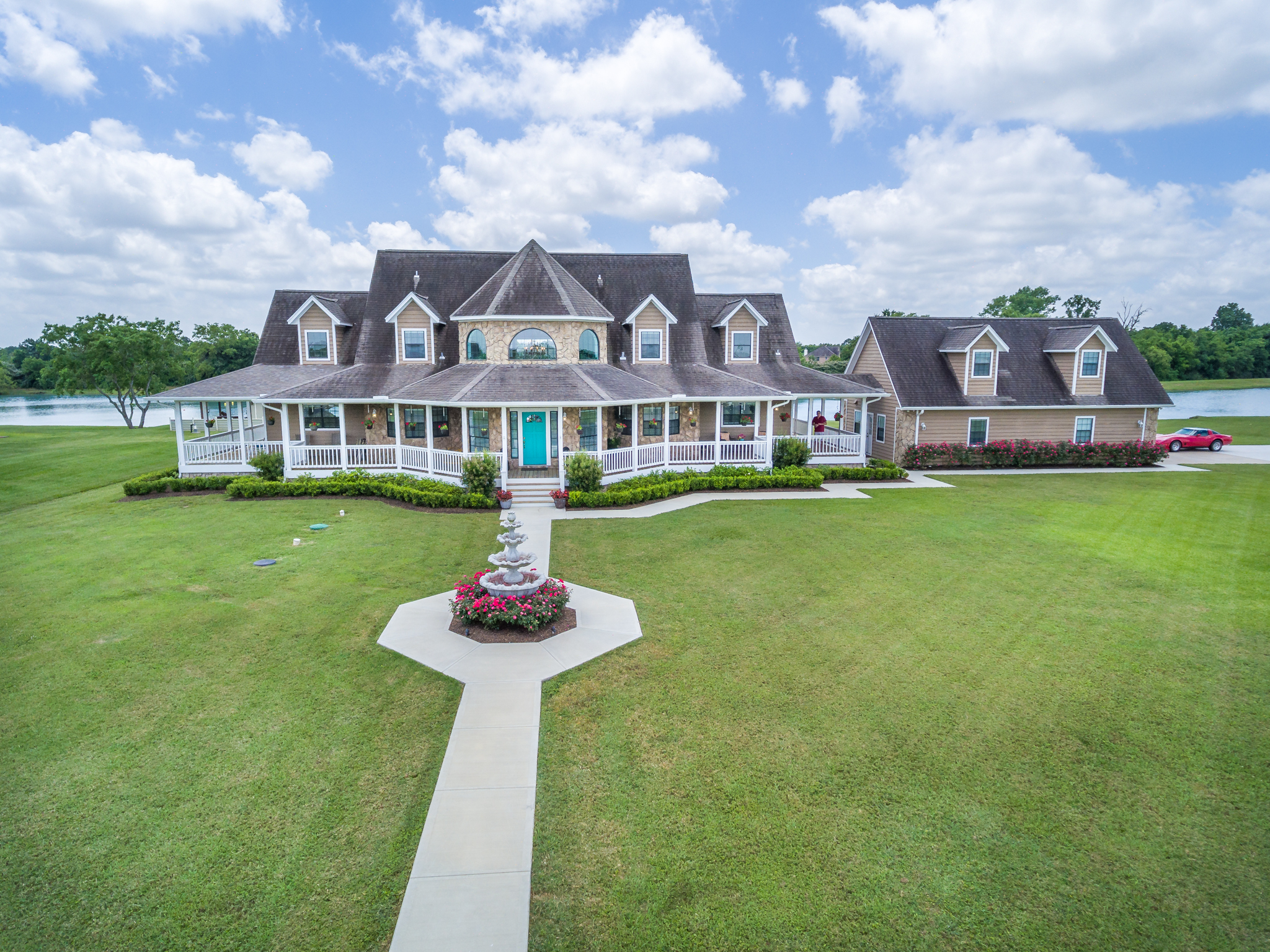 Two-story home with wraparound porch and a large front lawn