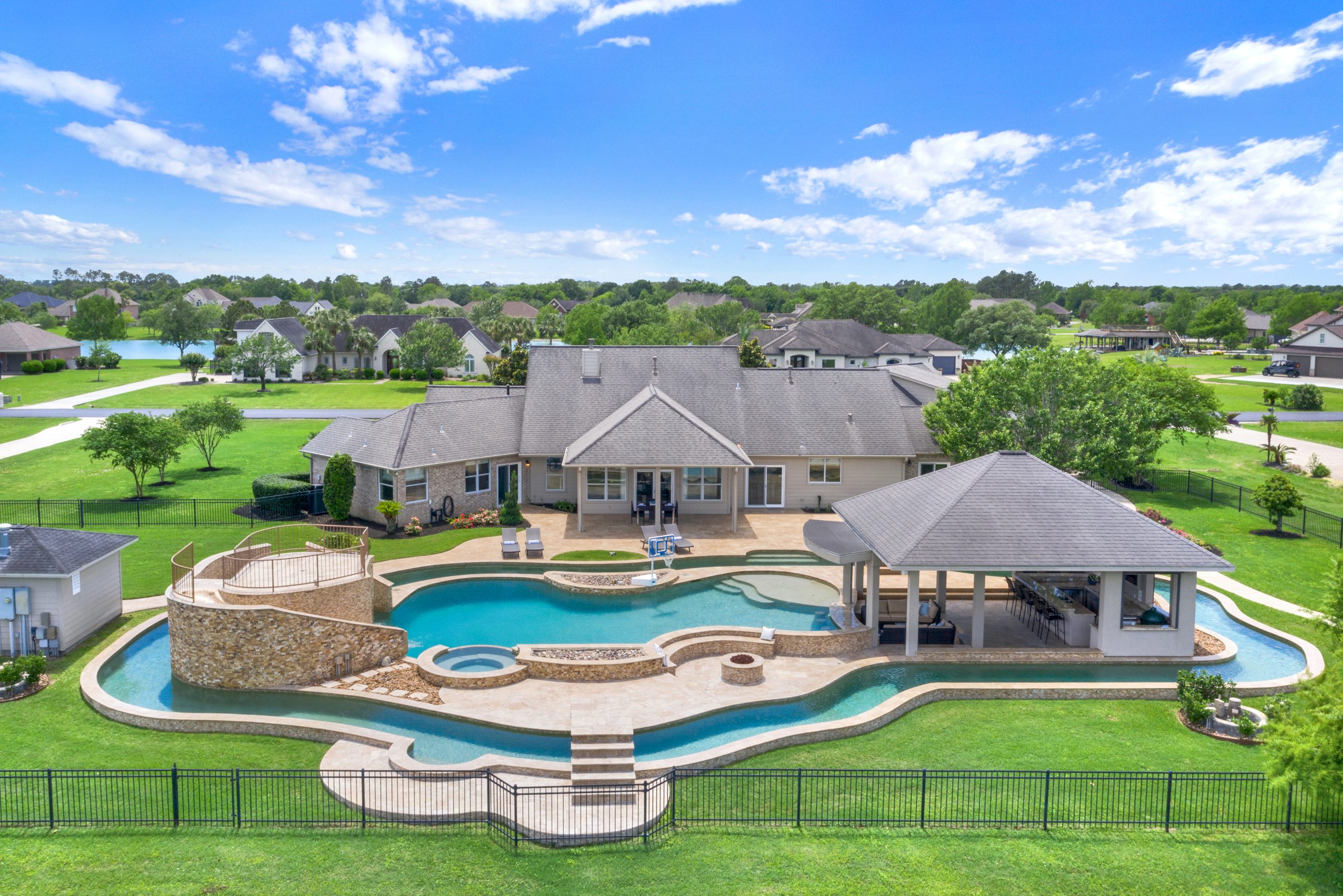 Aerial view of a backyard with resort-style pool and outdoor pavilion