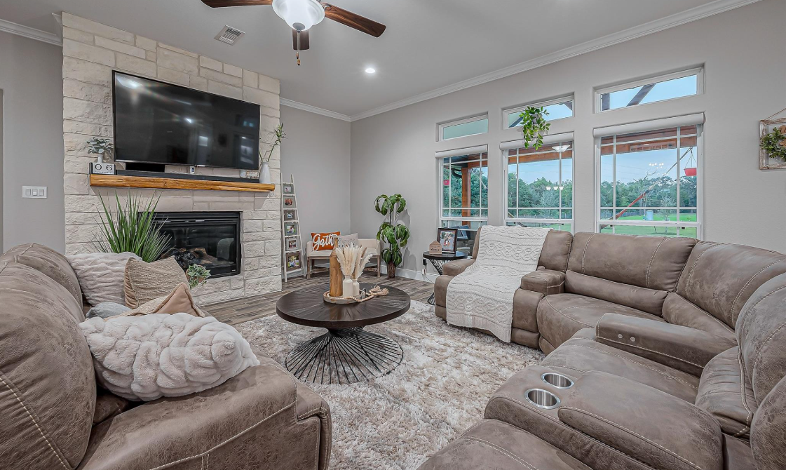 Living room with stone fireplace and large windows